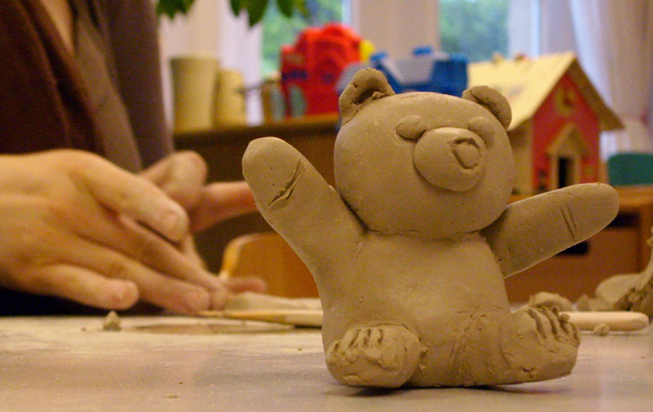 Kind beim Modellieren eines Teddys mit Ton
